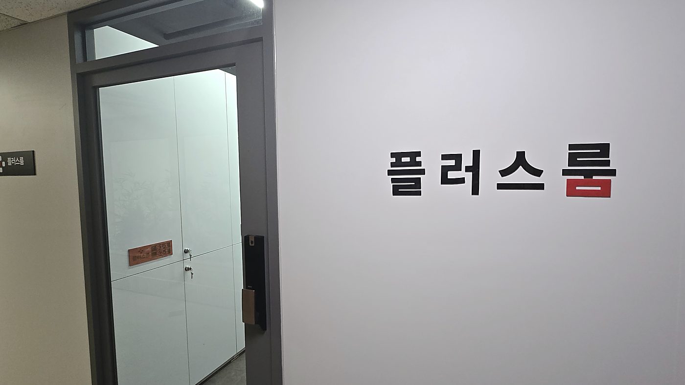 입구 벽면의 플러스룸 레터링 사인